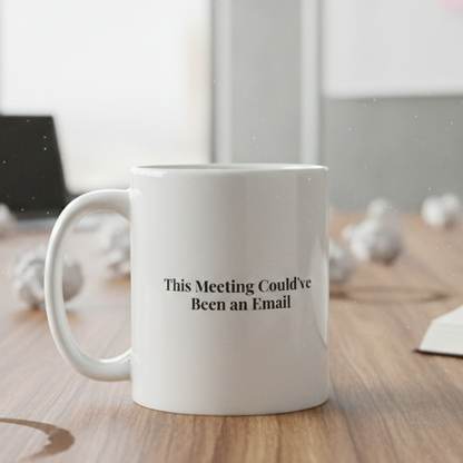Mug with 'This Meeting Could've Been an Email' text on a wooden table in a meeting room.