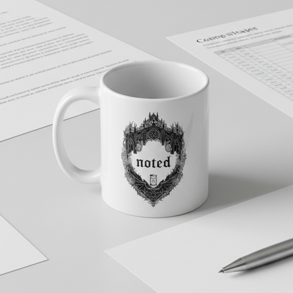 White mug with 'noted' design on a desk with papers and a pen