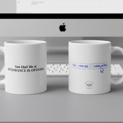 Two white mugs with humorous text designs in front of a computer screen.