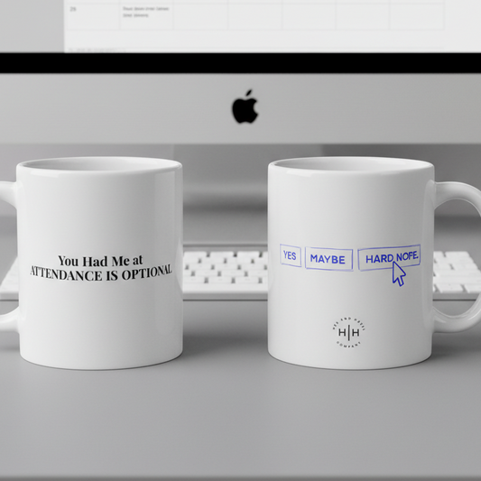 Two white mugs with humorous text designs in front of a computer screen.